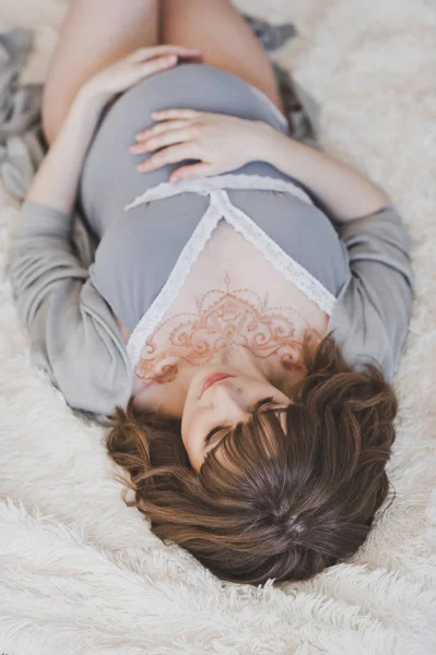 Egy terhes lány fekszik között fehér szőrme 1101. — Stock Fotó