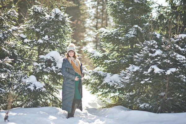 Beautiful girl in a down jacket on the background of snow covere — Stock Photo, Image