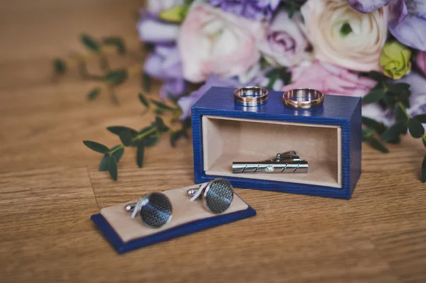 Cufflinks and tie clasp next to the bouquet 1174. — Stock Photo, Image