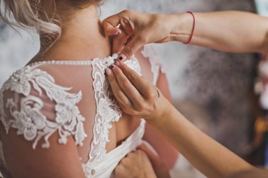 Anne kızının gelinlik giymesine yardım ediyor..