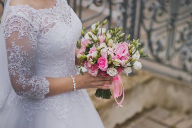 1980 'de elinde bir buket çiçek tutan beyaz elbiseli bir kız..