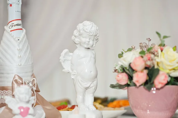 Estatua de un angelito blanco sobre la mesa entre las flores 18 —  Fotos de Stock