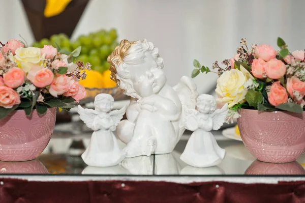 Posąg małego białego anioła na stole wśród kwiatów 18 — Zdjęcie stockowe