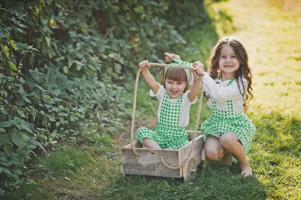 The elder sister carries the younger sister on the cart 1883. — Stock Photo, Image