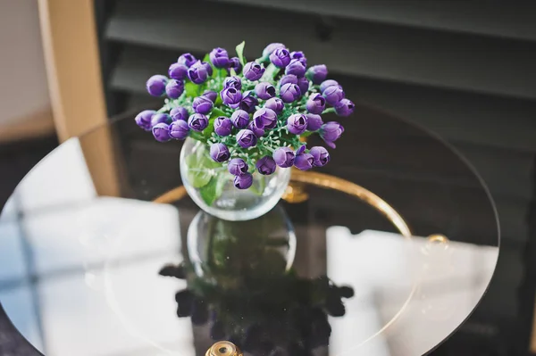 Un bouquet de petites fleurs bleues sur une table en verre 1976. — Photo