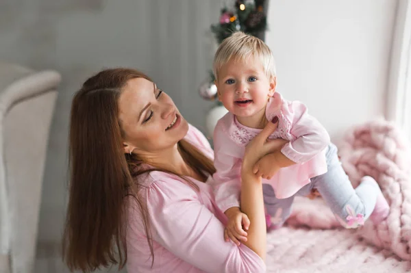 El bebé está jugando con su madre acostada en una manta rosa 2010 — Foto de Stock