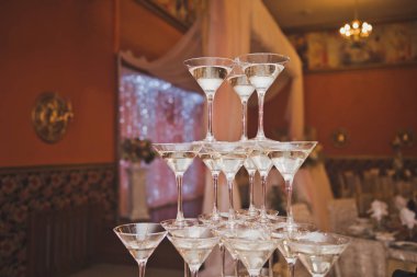 Şampanya kadehleri piramidi şenliğin arka planında ha