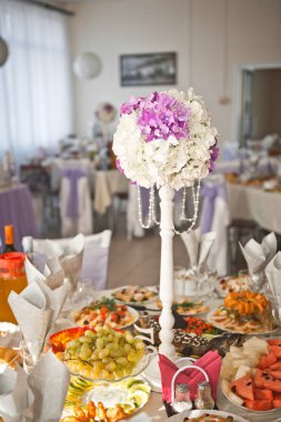 Tatil masasında küresel bir buket olan uzun ve dar bir duruş.