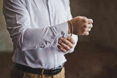 Adam kar beyazı bir gömleğin kolunu 2219 'a bağlıyor..