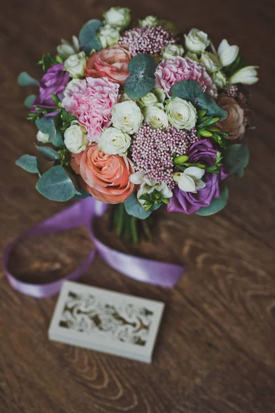 Anéis de casamento em uma bela caixa esculpida e um buquê colorido 2 — Fotografia de Stock