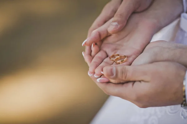 Der Ehemann umarmt sanft die Hände der Braut bei der Hochzeit — Stockfoto