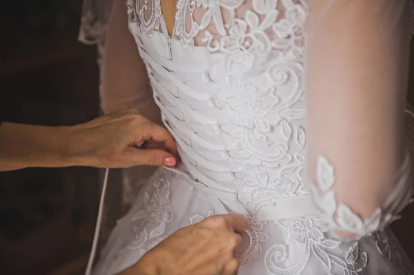 Mães gentis mãos rendam o vestido de noiva em sua filha 2277 — Fotografia de Stock