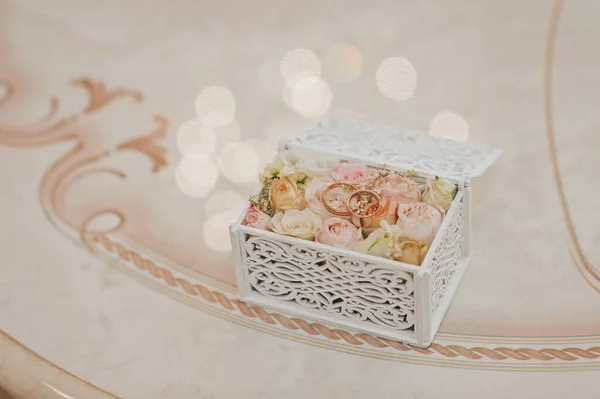 Anéis de casamento em uma caixa elegante em um substrato de botões de rosa 2301. — Fotografia de Stock