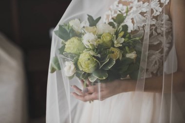 Gelin 2477 numaralı düğün buketini tutuyor..