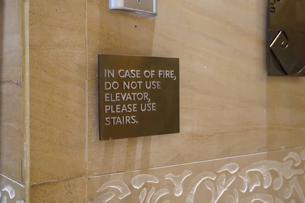 A sign that says, In Case Of Fire, Do Not Use Elevator, Please Use Stairs, which direct people of what to do in case of an fire emergency. — Stock Photo, Image