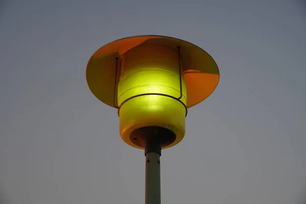 Straatlantaarnpaal met het avondzicht op de skyline. Buitenlamp armatuur met lucht achtergrond. Een enkele kap straatlantaarn. — Stockfoto