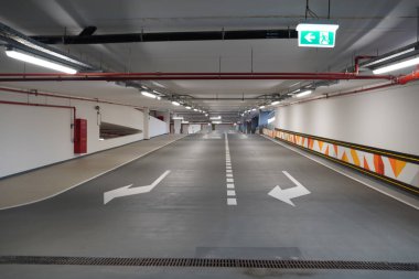 Otoparka dik asfalt inişi. Otoparkın içinde yeni inen yollar. Kapalı otopark çıkışı perspektifi. Çift şerit.