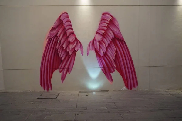 Dubai Uae December 2019 Rózsaszín szárnyak a falon. Nagy emberi méretű rózsaszín angyalszárnyak festve. Festett falak, graffiti művészet, és szobrok díszítik az utcákat. — Stock Fotó