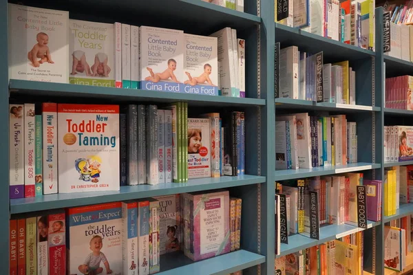 Regały w bibliotece z wieloma książkami rodzicielskimi na sprzedaż. Rodzicielstwo, poradniki dla maluchów. Książki dla dzieci. Książki dla maluchów. Czego się spodziewać, gdy spodziewasz się dziecka. Przewodnik po ciąży - Dubaj Zjednoczone Emiraty Arabskie grudzień 2019 — Zdjęcie stockowe
