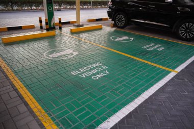 Otoparkta yeşil elektrikli araç şarj istasyonu tabelası. Elektrikli araç park yeri. Elektrikli araba şarj istasyonu. Dubai BAE Aralık 2019