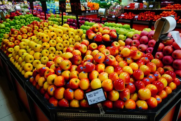 Sekelompok apel merah, kuning dan hijau di kotak di supermarket. Apel dijual di pasar umum. Makanan organik Apel segar di toko, toko - Dubai UAE Desember 2019 — Stok Foto