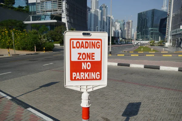 Dubai UAE December 2019 Röd och vit skylt mot ingen parkering i lastzonen utanför en byggnad. Bostads- och handelsområde med ingen parkering, Laddar Zon skylt. — Stockfoto