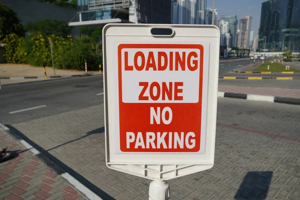 Dubai UAE December 2019 Röd och vit skylt mot ingen parkering i lastzonen utanför en byggnad. Bostads- och handelsområde med ingen parkering, Laddar Zon skylt. — Stockfoto