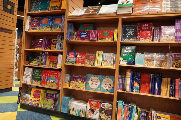 Satılık bir kitapçıda raflara kitap çizip boyayan çocuklar. Kütüphane çocukları kitapları bölümü. Kütüphane 'deki kitaplıkta satılık kitapların çeşitliliği. Süpermarket. Dubai Uae Aralık 2019. — Stok fotoğraf