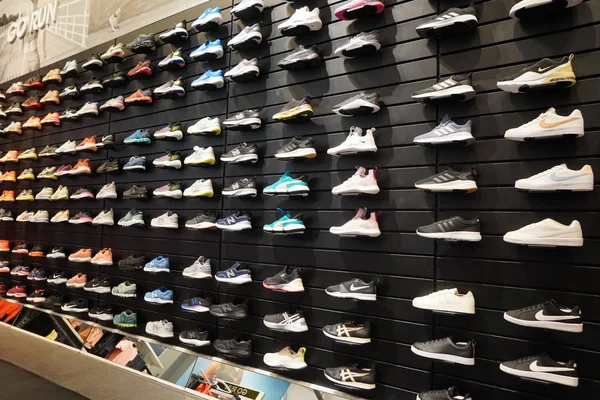 Winkel display van een heleboel sportschoenen op een muur. Een uitzicht op een muur van schoenen in de winkel. Moderne nieuwe stijlvolle sneakers voor dames en heren - Dubai Verenigde Arabische Emiraten december 2019 — Stockfoto