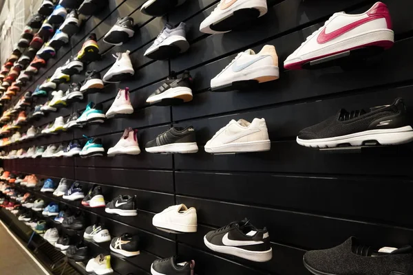 壁にスポーツシューズの多くのショップ表示。店内には靴の壁が見える。男性と女性のための靴を実行している現代的な新しいスタイリッシュなスニーカー-ドバイUAE 12月2019 — ストック写真
