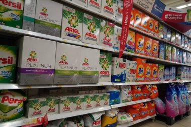 Kutularda farklı marka çamaşır tozu bulunan süpermarket vitrinleri. Toptan satış. Gel-git, Ariel, Omo çamaşır deterjanı kutuları Dubai Uae Aralık 2019 'da bir mağazada satışa sunuldu.