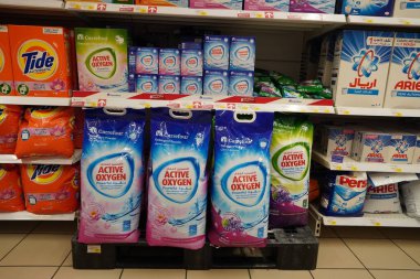 Kutularda farklı marka çamaşır tozu bulunan süpermarket vitrinleri. Toptan satış. Gel-git, Ariel, Omo çamaşır deterjanı kutuları Dubai Uae Aralık 2019 'da bir mağazada satışa sunuldu.
