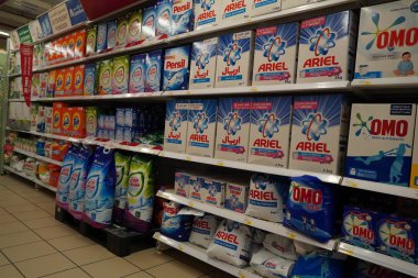 Kutularda farklı marka çamaşır tozu bulunan süpermarket vitrinleri. Toptan satış. Gel-git, Ariel, Omo çamaşır deterjanı kutuları Dubai Uae Aralık 2019 'da bir mağazada satışa sunuldu.