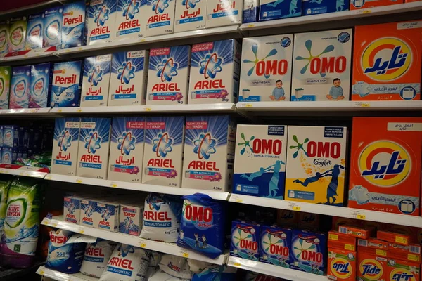 Supermarket display with different brands of washing powder in boxes. Wholesale. Tide, Ariel, Omo laundry detergent boxes lined up for sale in a store shelf- Dubai UAE December 2019 —  Fotos de Stock