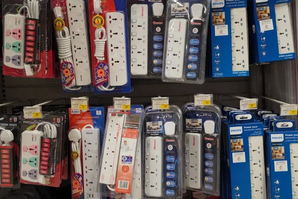 Selection of extension 3 pin plug socket wire on supermarket. Many adapter power plug or extension cord hang on the shelf. Packed ready different kinds of power strips. - Dubai UAE December 2019 — Photo