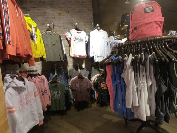 두 바이 아랍에미리트 (Dubai UAE) - 2019 년 6 월 - 두 바이의 의류 가게에 슈퍼 드라이의 옷이 있다. 슈퍼 드라이 셔츠 와 베이지 가 내부에서 팔리고 있다. — 스톡 사진