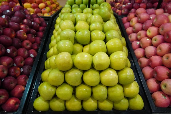 Bündel roter, pinkfarbener, gelber und grüner Äpfel auf Kartons im Supermarkt. Äpfel, die auf öffentlichen Märkten verkauft werden. Biolebensmittel Frische Äpfel im Laden, Geschäft - Dubai VAE Dezember 2019 — Stockfoto