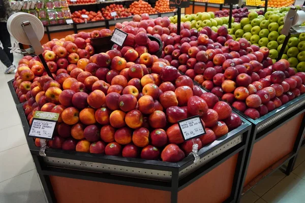 Bunch of red, yellow and green apples on boxes in supermarket. Apples being sold at public market. Organic food Fresh apples in shop, store - Dubai UAE December 2019 — Stock Photo, Image