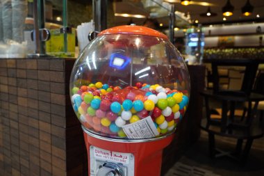 Bozuk para işleten sakız makinesinde renkli sakız. Atlıkarınca Gumball Machine Bank bir dükkanın dışında tutuluyor. - Dubai Uae Ocak 2020