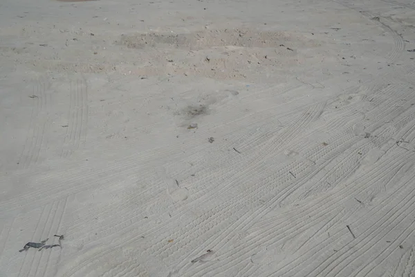 Pistas de neumáticos de coche en la arena de la playa en perspectiva. Huellas de neumáticos de coche en un camino que conduce a la playa cubierta de arena. Ruedas en el suelo. Pista de Ruedas en Muddy Ground. Off Road 4X4 Rueda pistas de automovilismo . — Foto de Stock
