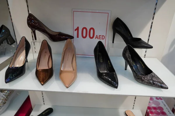 Новая красочная обувь с высоким каблуком на стойках в торговом центре. Вывеска со шпильками на витрине магазина. Обувь на высоких каблуках на полке магазина - Дубай, ОАЭ, январь 2020 г. — стоковое фото