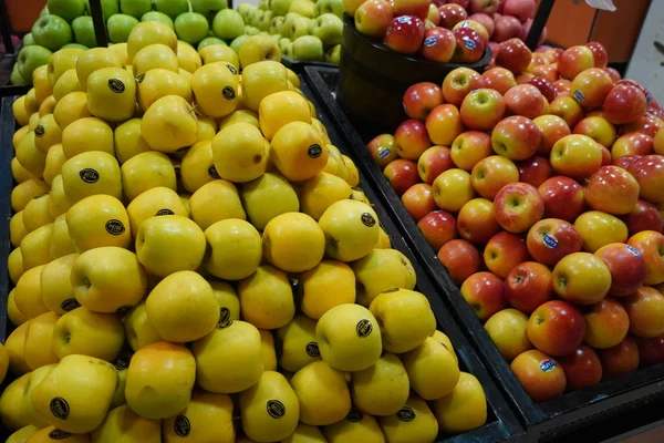 Manojo de manzanas rojas y amarillas en cajas en el supermercado. Las manzanas se venden en el mercado público. Alimentos orgánicos Manzanas frescas en la tienda, tienda - Dubai Emiratos Árabes Unidos diciembre 2019 — Foto de Stock