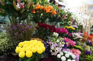 Renkli güller ve diğer farklı çiçeklerle dolu buket. Çiftçi pazarındaki çiçekçi dükkanının girişinde. Renkli şakayık, güller vesaire. Çiçekçi dükkanının rafında saksılar. Dubai BAE Aralık 2019