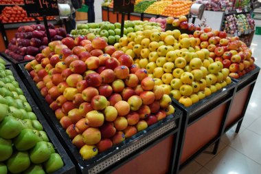 Süpermarkette kutuların üzerinde kırmızı, sarı ve yeşil elmalar var. Elmalar halka açık pazarda satılıyor. Organik yiyecekler mağazada taze elmalar Dubai BAE Aralık 2019