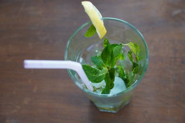 Masada limon, nane, saman ve buzlu mojito ile dolu boş bir bardağın en üst görüntüsü..