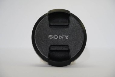 Beyaz arka planda Sony Camera Lens Cap. Kamera merceğinin damgalı şapkası Sony 'yi fotoğrafçılık hobisi olanlara aksesuar olarak gösterdi. : Udaipur Hindistan - Mart 2020
