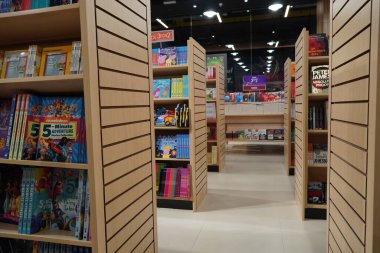 Kütüphane kitaplarının rafları arasında bir koridor, kütüphane gibi eğitim arka planında. Kitapçıdaki kitaplarla dolu rafların arasındaki geçit. : Dubai BAE - Mart 2020