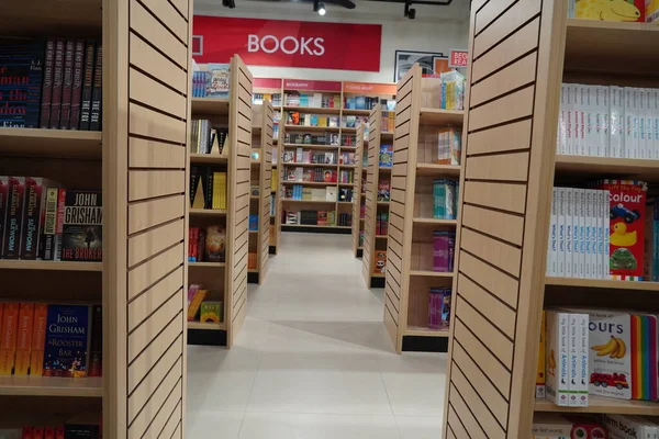 Kütüphane kitaplarının rafları arasında bir koridor, kütüphane gibi eğitim arka planında. Kitapçıdaki kitaplarla dolu rafların arasındaki geçit. : Dubai BAE - Mart 2020