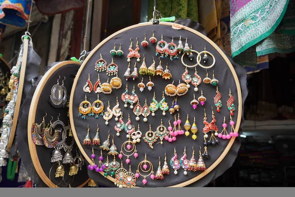 Udaipur Hindistan 'daki sokak pazarında turistler için asılı duran renkli el yapımı küpeler. Sokak pazarında satılık renkli güzel ve şık küpeler..