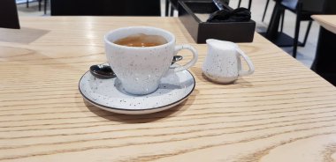 Kafedeki masada kremalı tatlı ile kahve.